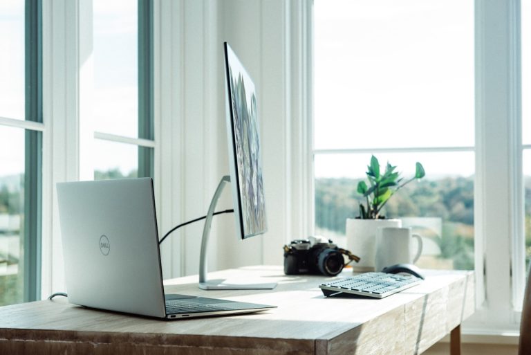 Modern work-from-home desk setup with laptop stand, keyboard and wireless mouse